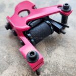 Red tattoo machine frame with bolt