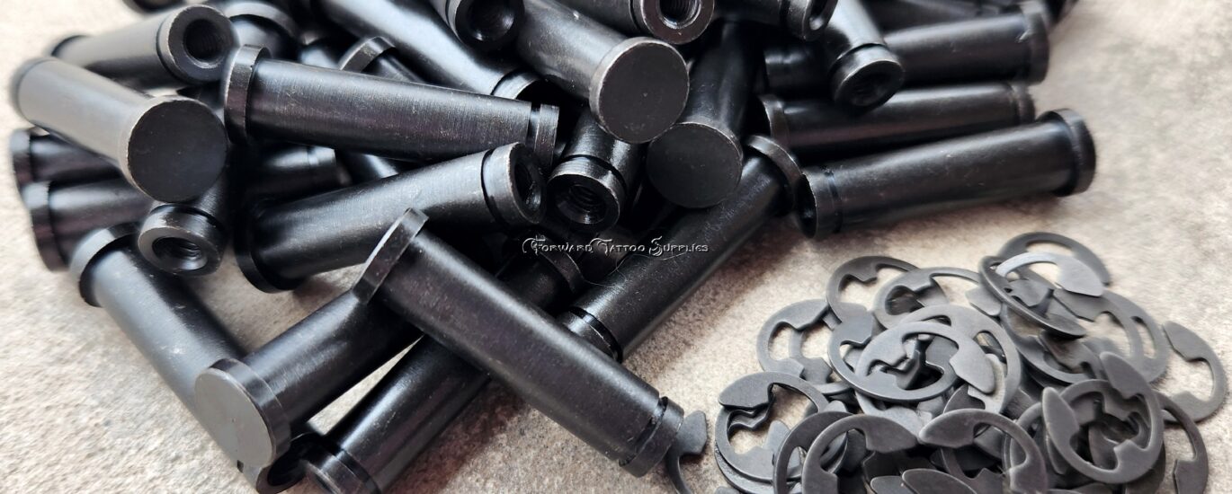 Black plastic wall anchors and screws laid out on a surface.