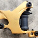 Close-up of a yellow mechanical part with black rubber components.
