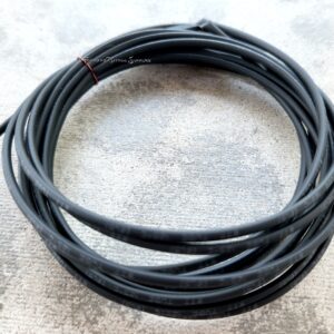 Coiled black cable neatly arranged on a concrete surface.