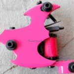 Bright pink tattoo machine with a sleek design.