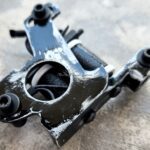 Close-up of a worn black mechanical part with chipped paint.