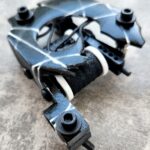 Close-up of a tattoo machine resting on a surface.