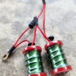 Close-up of two green and red coil pickups with red wires.