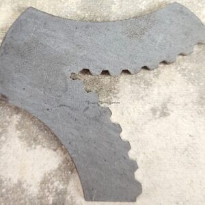 Metal gear-like object on textured surface.