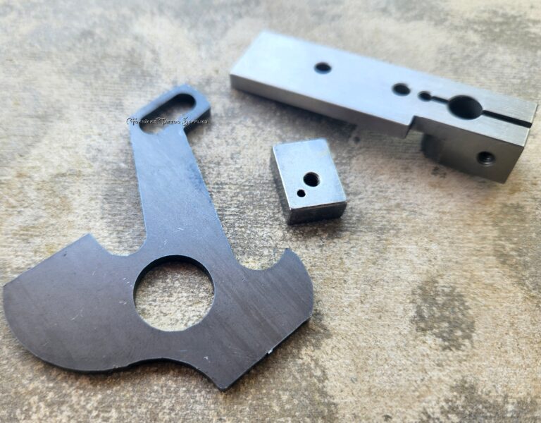 Metal machine parts on textured surface.