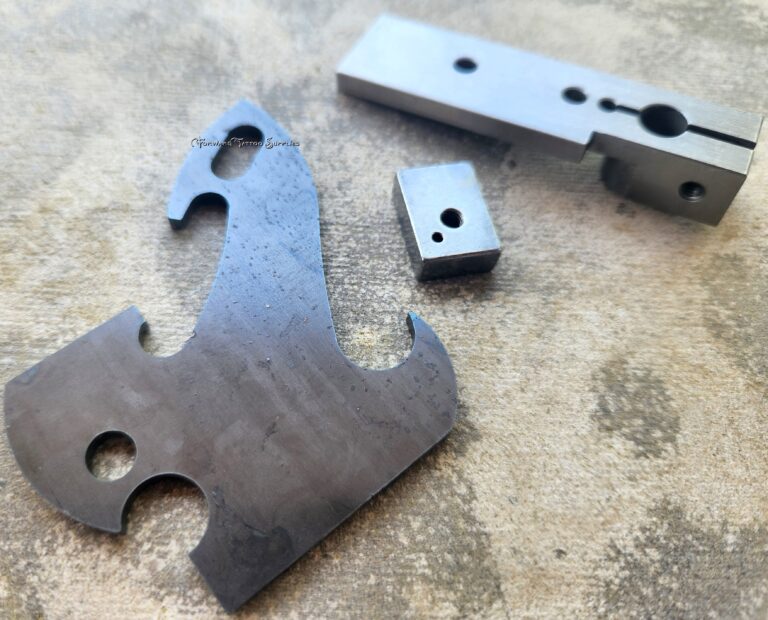 Metal machine parts on textured surface.