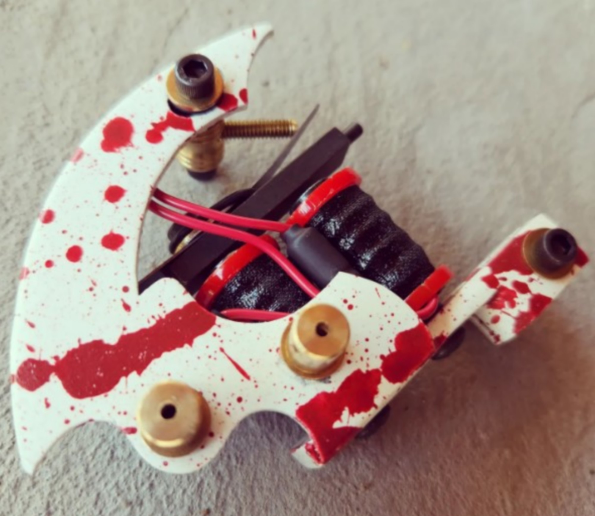 Close-up of a blood-splattered tattoo machine.