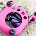 Pink coil tattoo machine detail on stone