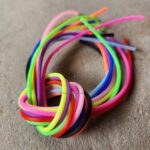 Colorful flexible tubes twisted into a knot on a surface.
