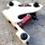 White frame tattoo machine revealing copper coils