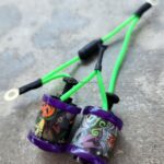 Two colorful, decorated small containers connected with green strings.