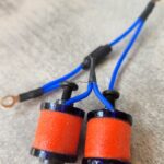 Close-up of electronic components with blue wires and orange coils.