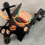 A coil assembly with wires and connectors on a plastic frame.