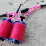 Close-up of pink hair rollers with black clips on a gray surface.