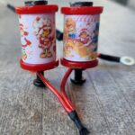 Two small, decorative red and white lanterns with cartoon designs.