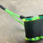 Close-up of a green and black foam-padded object with elastic bands.