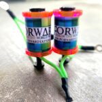 Two colorful cylindrical coils connected by wires on a surface.