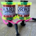 Close-up of vibrant tattoo ink bottles on a stand.