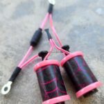 Close-up of a fishing line with two pink and black bobbers attached.