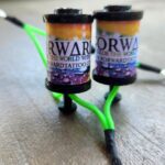 Two colorful vape cartridges with 'Forward' labels and a green cable.