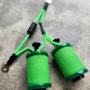 Green electrical grounding cables with ring terminals and coils.