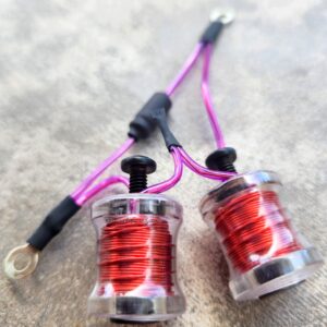 Close-up of two small coils wrapped in red wire with purple wires attached.