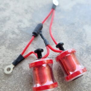 Red electrical connectors with metal terminals on a gray surface.