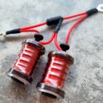 Close-up of two red LED lights with black connectors on a gray surface.