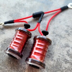 Close-up of two red LED lights with black connectors on a gray surface.