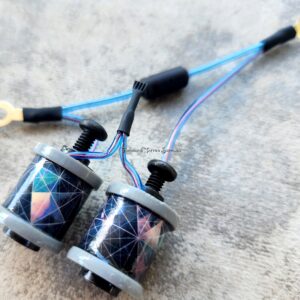 A pair of fishing reels with blue lines on a textured surface.