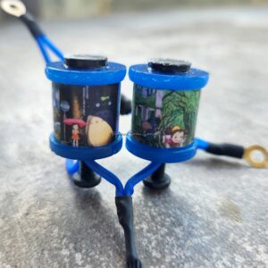 Two blue cylindrical devices with gears and wires mounted on a blue frame.