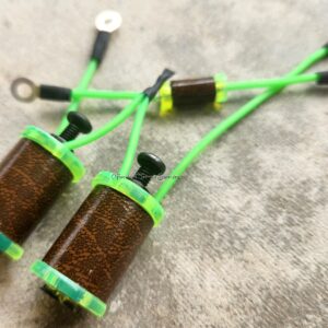 Close-up of green and brown fishing rod tip guides on a textured surface.
