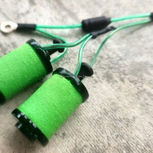 Close-up of green electrical coil components on a gray surface.