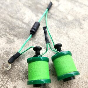 Two green fishing line spools connected by wires with black connectors.