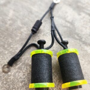 Close-up of black electrical cables with yellow and green connectors on a gray surface.