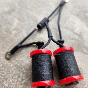 Close-up of a black and red fishing rod tip with line guides.