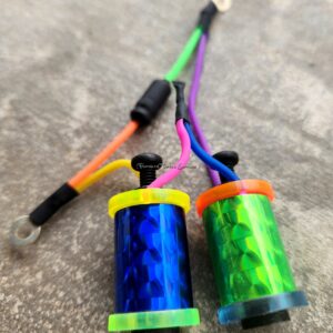 Two colorful spools with vibrant threads and black connectors.