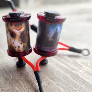 Two used fuel filters with residue and stains on a wooden surface.