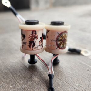Two wooden yo-yos with intricate designs and attached cords.