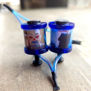 Two small blue containers with liquids connected by tubes on a wooden surface.