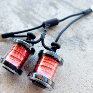 Close-up of two fishing reels with red fishing line.