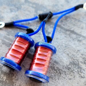 Close-up of two red and blue electrical coils on a gray surface.