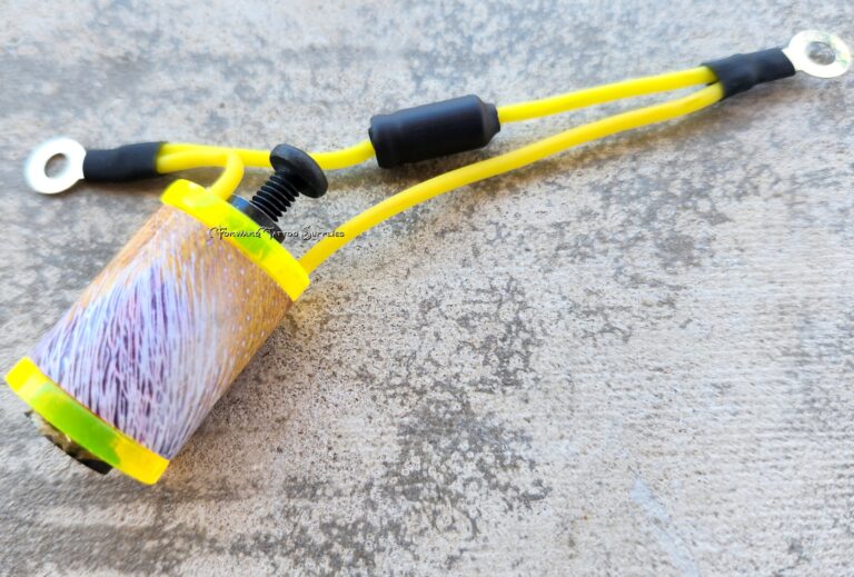 Close-up of a yellow slingshot on a textured surface.