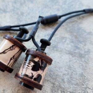 Close-up of two copper coils and wires on a concrete surface.