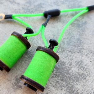 Close-up of green thread spools on a gray surface.
