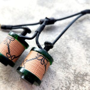 Handcrafted earrings with green accents and intricate wire wrapping.