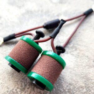 Close-up of two fishing rod line guides with green frames.