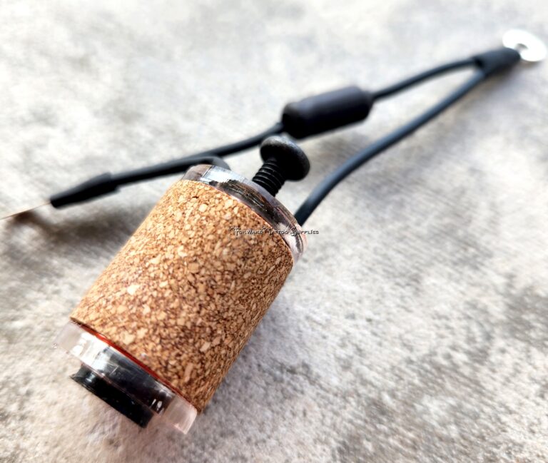 Close-up of a fishing rod handle with cork grip on a textured surface.