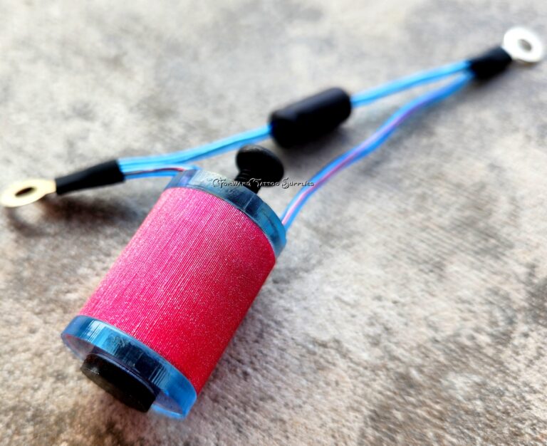 A bright pink spool of thread attached to a blue sewing tool.